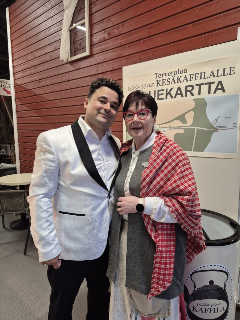 Villa Vinon vanha emäntä Sirpa kansallisasussaan laulaja Amadeuksen kanssa Kesäkaffilalla.